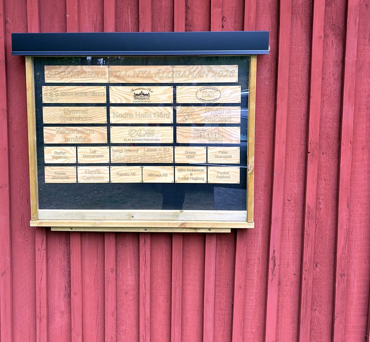 Sponsortavla på klubbstugans vägg: ”Sponsorer till nya älgbanan 2026”.